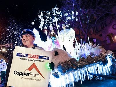 man holding sign in front parade float